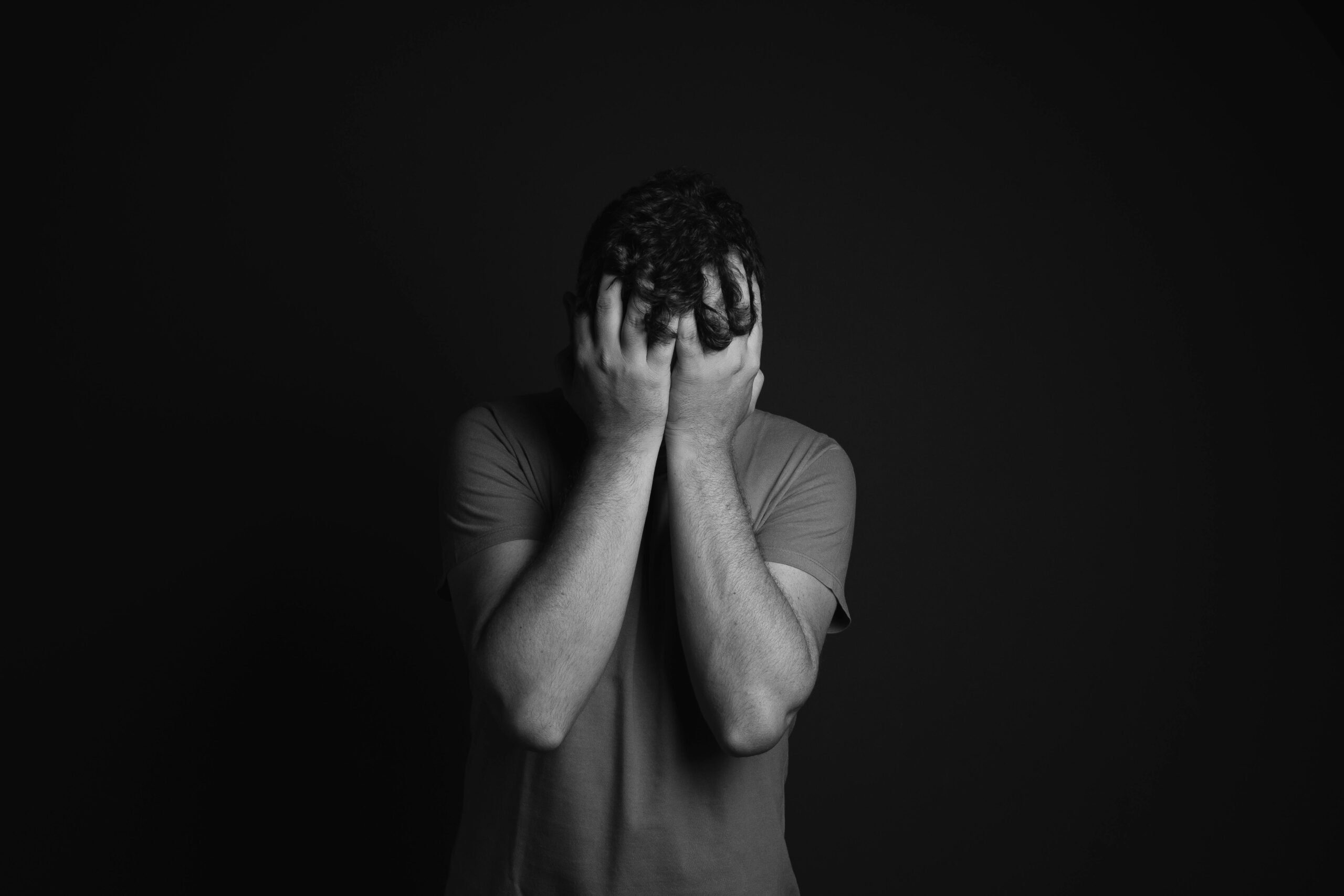 Stylized graphic of a person with their head in their hands, highlighting the quiet nature of depression signs.