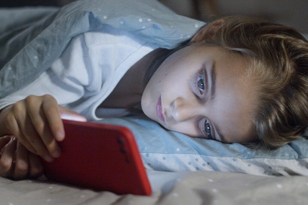 A girl watching mobile during sleep